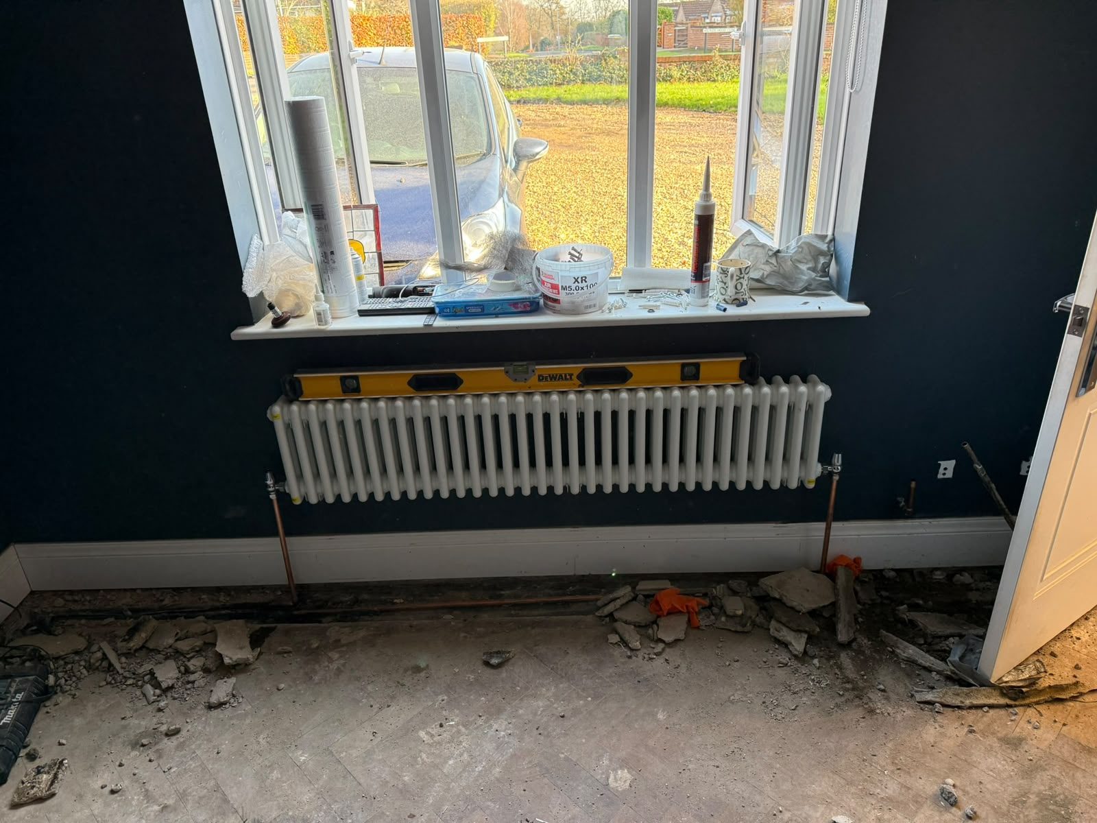 Traditional column radiator being installed in a room undergoing renovation