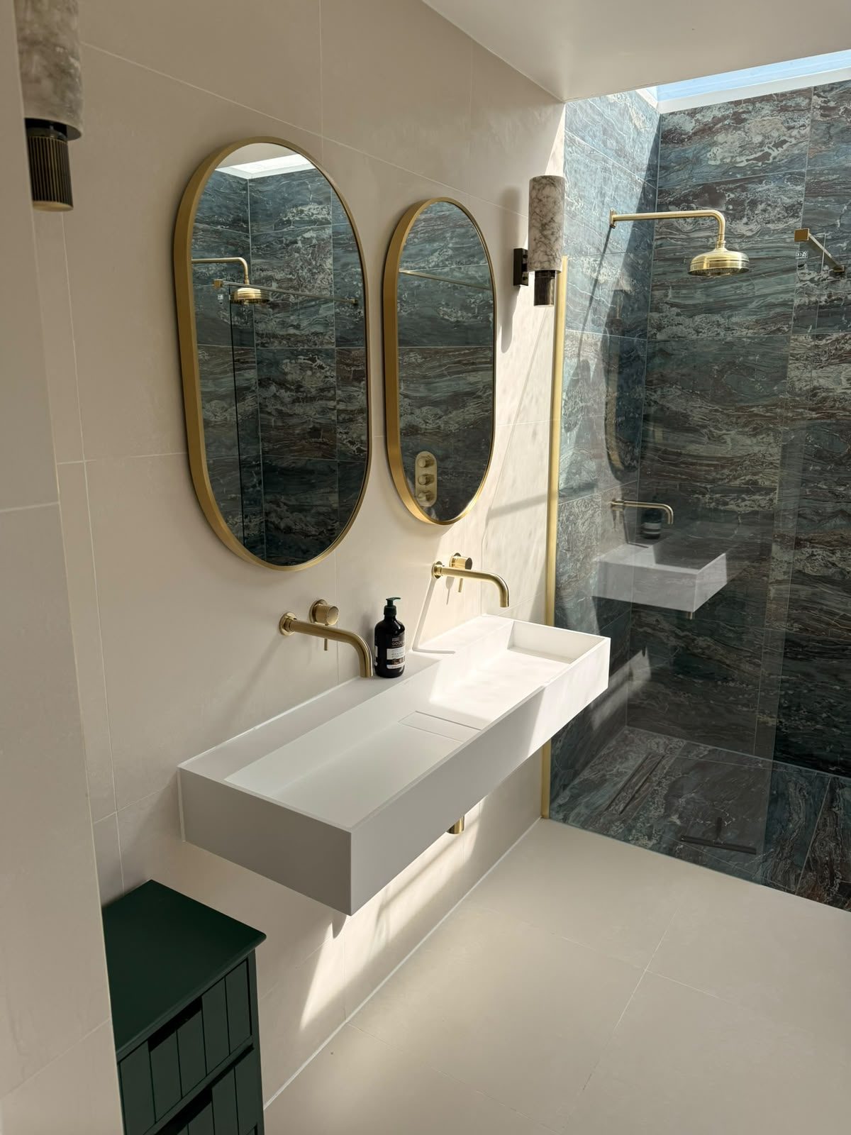 Double trough basin with gold taps in a newly installed luxury bathroom with blue marble-effect tiling